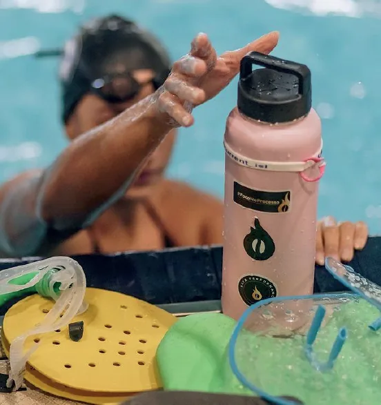 Garrafa com stickers da Caffeine Army na beira da piscina