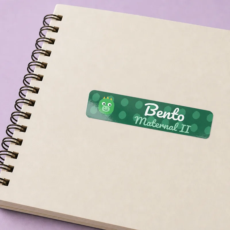 Caderno com etiqueta de dinossauro e o nome Bento
