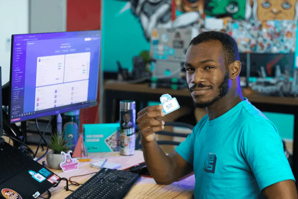 Josh mostrando um sticker na mesa de trabalho