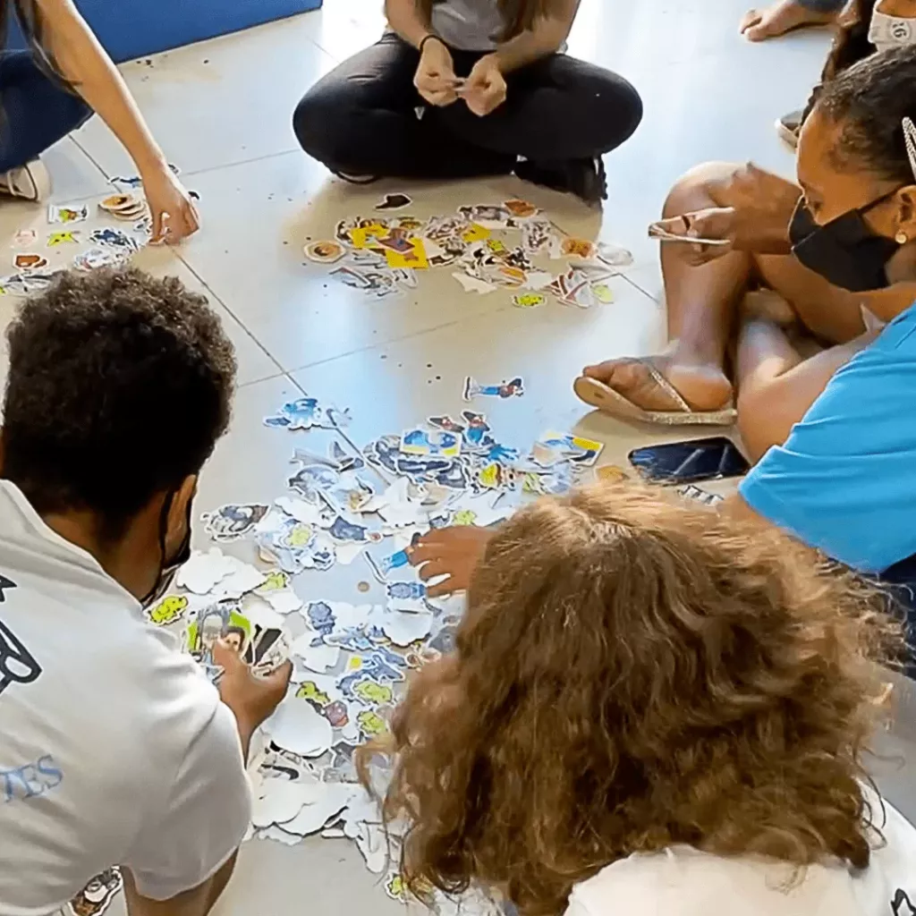 Crianças separando adesivos no chão