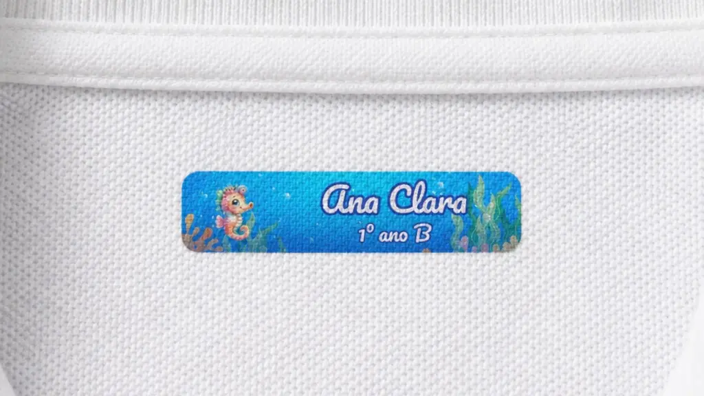 Etiqueta termocolante com nome e turma na gola de um uniforme escolar branco